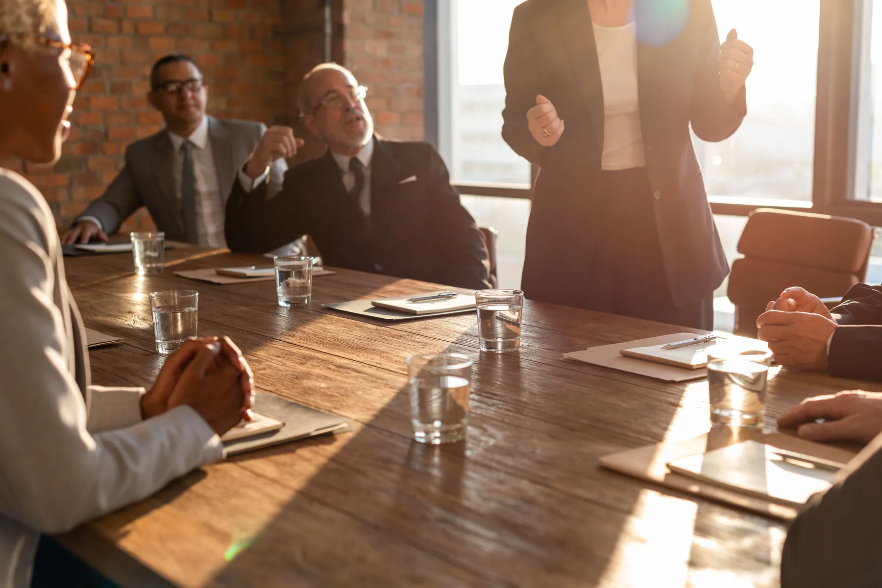 A group discussing figures around a boardroom table