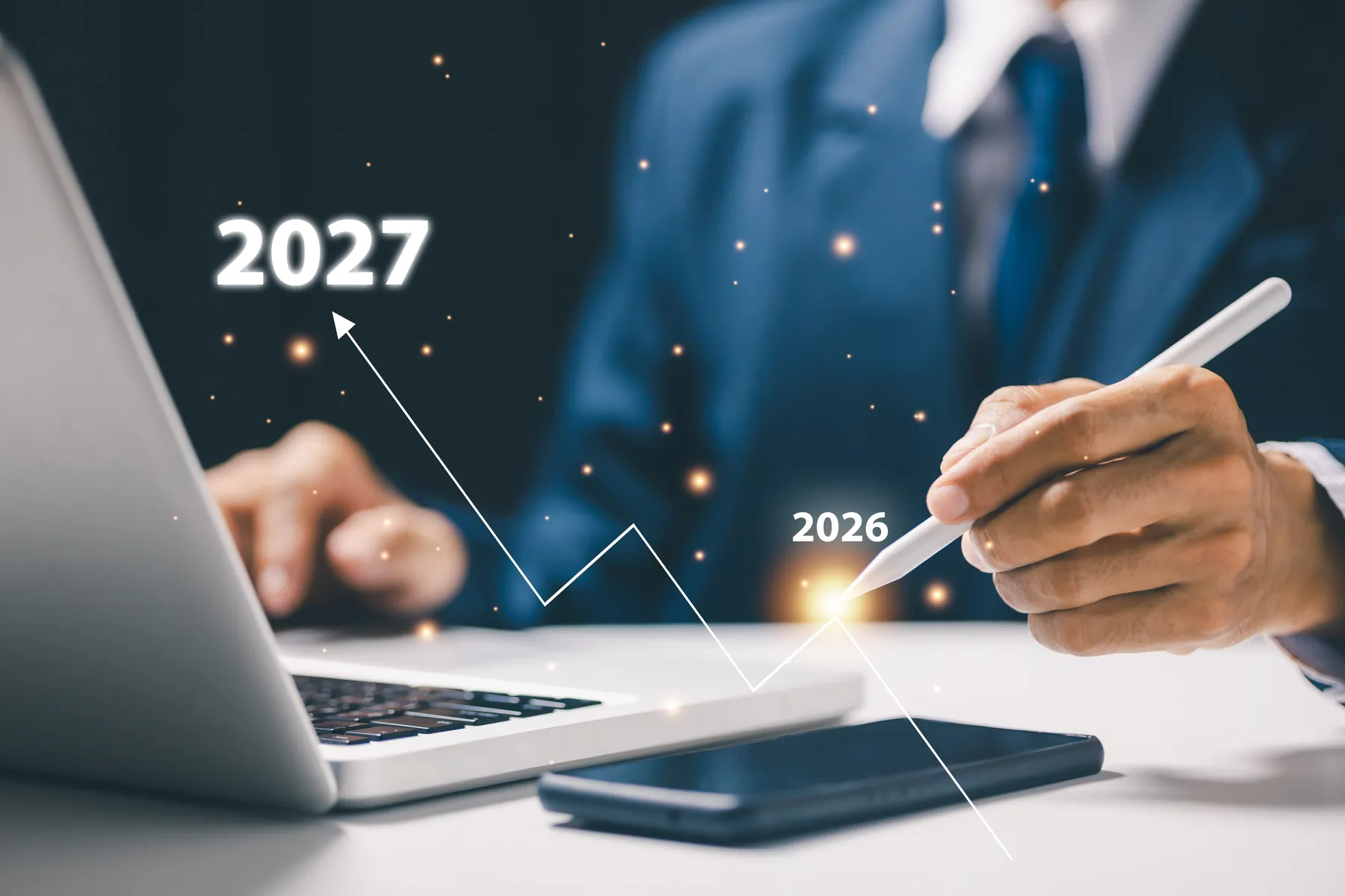 A laptop showing a rising growth chart during a planning discussion